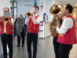 Vier Musiker in roten Westen spielen zusammen in einem Innenraum.