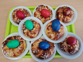 Bunte Eier auf Hefeteigbrötchen, serviert auf einem grünen Tablett.