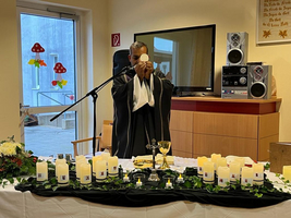Eine Person führt einen Ritual mit Kerzen und Gegenständen auf einem Tisch durch.