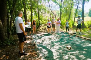 Eine Gruppe von Menschen hört einem Trainer in der Natur zu.