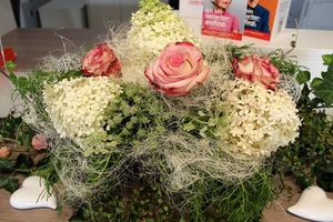 Blumenarrangement mit rosa Rosen und weißen Hortensien.