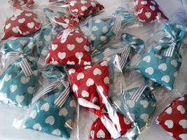 Bunte Tüten mit Herzen, verpackt in durchsichtiger Folie, liegen übereinander.
