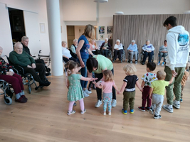 Kinder interagieren mit Erwachsenen in einem gemeinschaftlichen Raum.