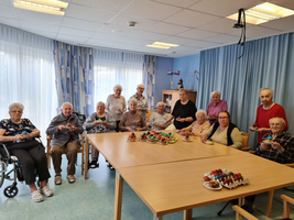 Ältere Menschen feiern zusammen mit bunten Kuchen und Ostereier auf dem Tisch.