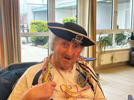 Ein älterer Mann trägt einen Piratenhut und bunte Schnipsel um den Hals.