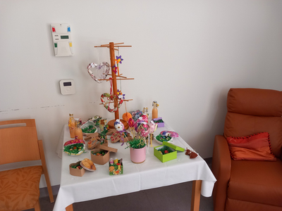 Ein Tisch gedeckt mit bunten Dekorationen und Snacks, daneben ein Sessel.