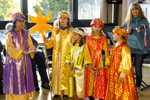 Sechs Kinder in festlichen Kostümen sind auf der Bühne versammelt.