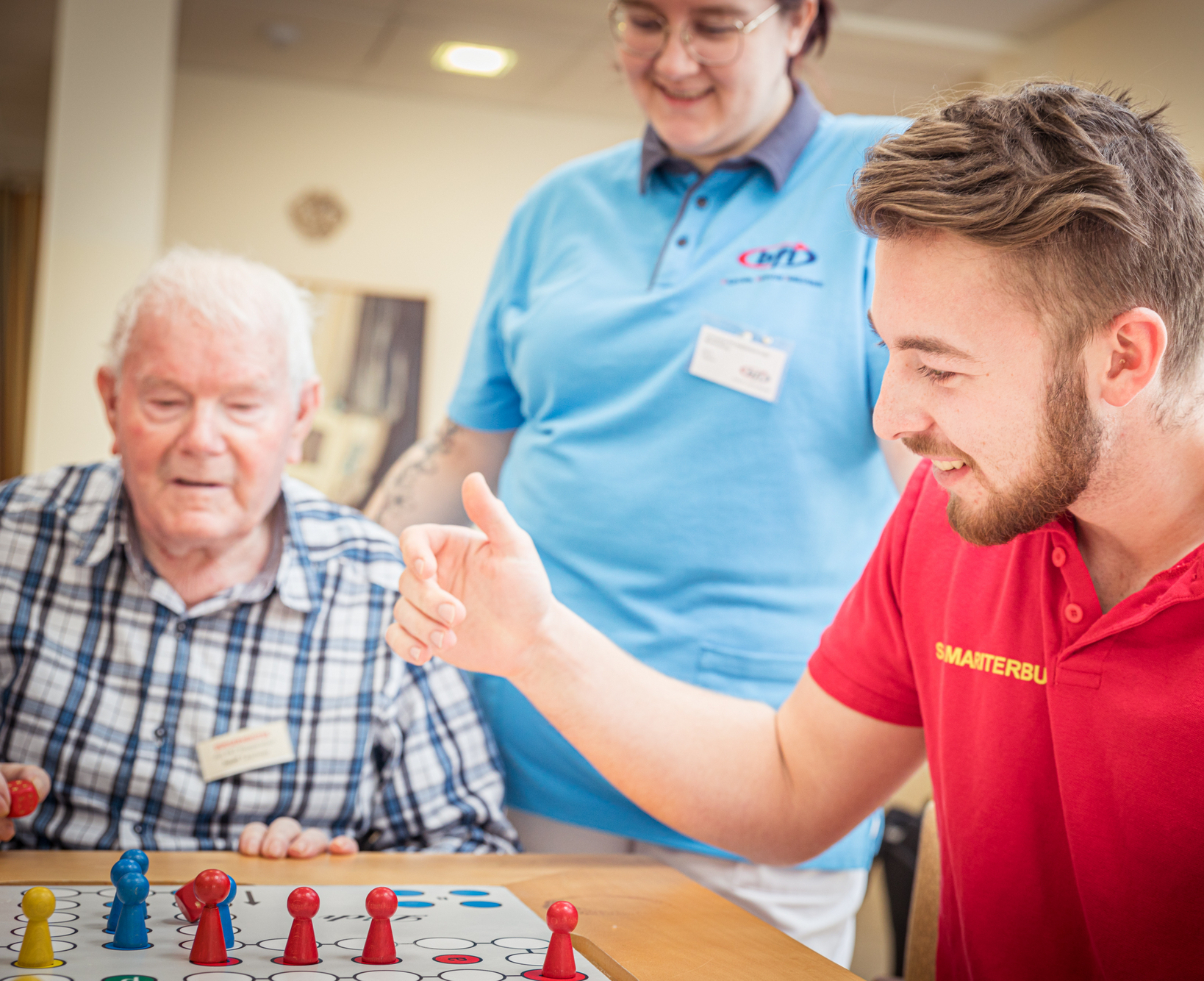 Zivildiener in der Pflege spielt mit Bewohner Mensch ärgere dich nicht