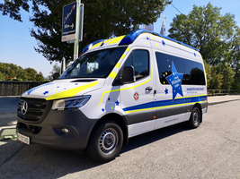 Ein Van mit farbenfrohem Design und dem Schriftzug „Samariter-Wünschefahrt“.