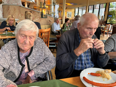 Zwei ältere Menschen sitzen am Tisch und essen in einem Restaurant.