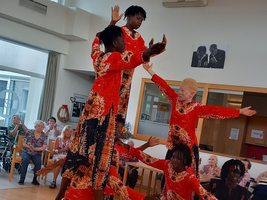 Sechs Tänzer in bunten Kostümen zeigen eine beeindruckende Gruppenchoreografie.