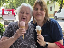 Eine ältere Frau und eine junge Frau genießen Eis in Waffeln.