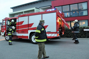 Feuerwehrleute steigen in ein Feuerwehrfahrzeug während eines Einsatzes ein.