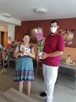 Eine Frau erhält von einem Mann eine Orchidee in einem Topf.