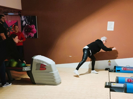 Eine Frau spielt in einem Bowling-Center und bereitet sich auf den Wurf vor.