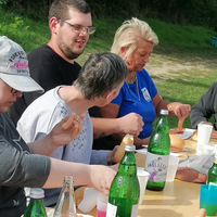 Eine Gruppe von Menschen sitzt an einem Tisch und genießt ein Essen im Freien.