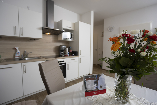 Moderne Küche mit Blumenstrauß auf einem Tisch.