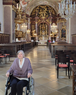 Eine Frau im Rollstuhl in einer prächtigen Kirche.