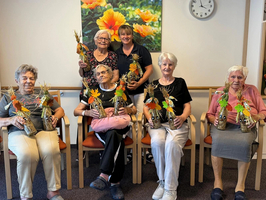 Gruppierung von Frauen mit herbstlichem Dekor in einer Einrichtung für Senioren.
