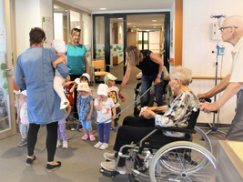 Kinder besuchen ältere Menschen in einem Gesundheitszentrum.