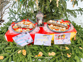Esstisch mit verschiedenen Plätzen für festliche Snacks und Lichterdekoration.