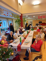 Ein festlich gedeckter Tisch mit Senioren in einem gemütlichen Speisesaal.