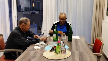 Zwei ältere Männer sitzen an einem Tisch und spielen Karten.