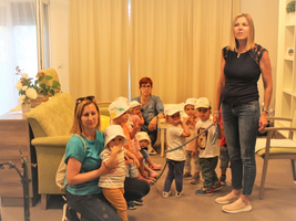 Eine Gruppe von Kindern mit Erzieherinnen in einem hellen Raum.