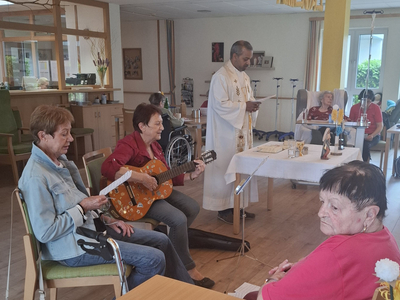 Eine religiöse Veranstaltung mit Musik und Gesang in einem Gemeinschaftsraum.
