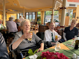 Ältere Menschen in einer geselligen Runde mit Getränken in einem Restaurant.