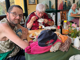 Geselliges Essen mit mehreren Personen und viel Essen auf dem Tisch.