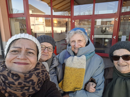 Eine Gruppe von vier Frauen posiert lächelnd vor einem Gebäude.