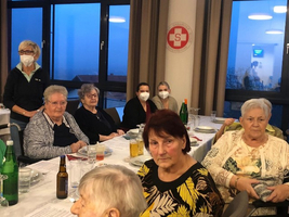 Gruppe von älteren Frauen, die an einem Tisch in einem Restaurant sitzen.