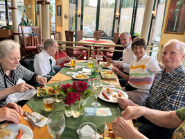 Eine Gruppe älterer Menschen genießt gemeinsam eine Mahlzeit an einem Tisch.