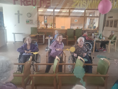 Ältere Menschen in Rollstühlen, die an einer Gemeinschaftsveranstaltung teilnehmen.