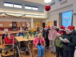 Kinder singen Weihnachtslieder für Senioren in festlicher Atmosphäre.